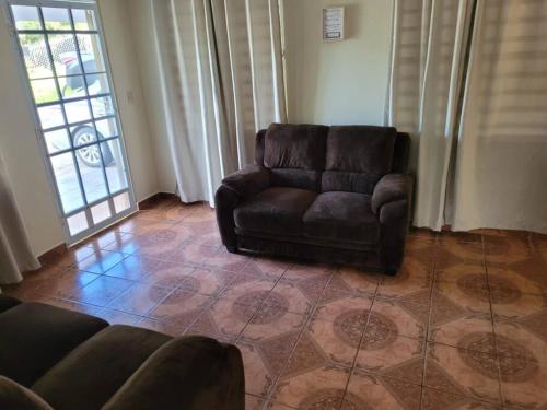 a brown leather couch sitting in a living room at Pal Campo in Hucares
