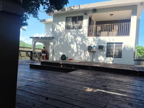 a person standing on a wooden deck in front of a house at Pal Campo in Hucares