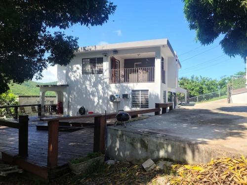 a white house with a wooden deck in front of it at Pal Campo in Hucares