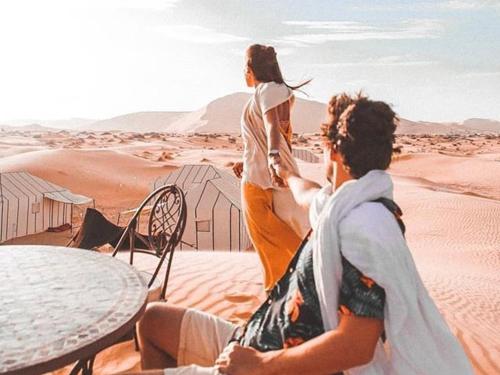 a couple of women standing in the desert at Sahara Zen Luxury Camp in Merzouga