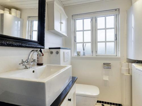 a bathroom with a sink and a toilet and a mirror at 4 person holiday home in Karrebæksminde in Karrebæksminde