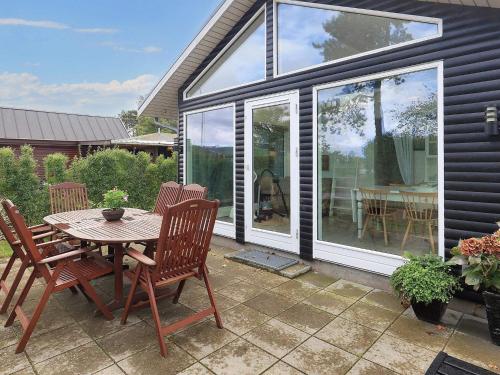 a screened in patio with a table and chairs at 4 person holiday home in Karrebæksminde in Karrebæksminde