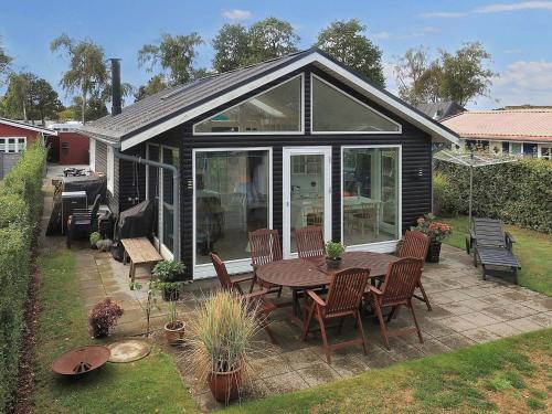 a screened in patio with a table and chairs at 4 person holiday home in Karrebæksminde in Karrebæksminde