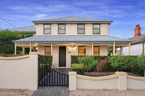 a large white house with a black gate at Spacious, Central 2bed 2bath, newly renovated gem! in Albury
