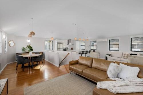 a living room and kitchen with a couch and a table at Spacious, Central 2bed 2bath, newly renovated gem! in Albury