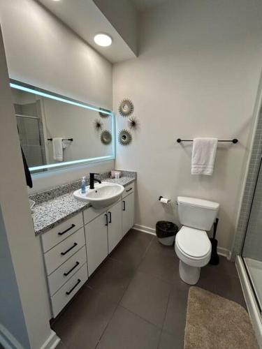 a bathroom with a toilet and a sink and a mirror at 1 Bedroom Studio Townhouse in Uptown Charlotte in Charlotte