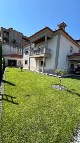 a large house with a green lawn in front of it at Casa Laurinda- Casa Inteira Marco de Canaveses in Marco de Canavezes