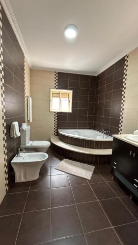 a bathroom with two sinks and a tub and a toilet at Casa Laurinda- Casa Inteira Marco de Canaveses in Marco de Canaveses