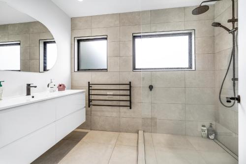 un bagno con lavandino e doccia di Golden Grove - Cambridge Holiday Home a Cambridge