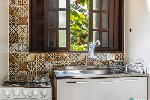 イリャベラにあるChalés da Libélula | Refúgio entre praia e natureza em Ilhabelaのシンクとコンロのあるキッチン