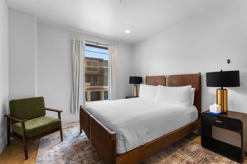 Un dormitorio con una cama y una silla y una ventana. en Blue River Flats Bld 3 203 By Summit County Mountain Retreats, en Silverthorne