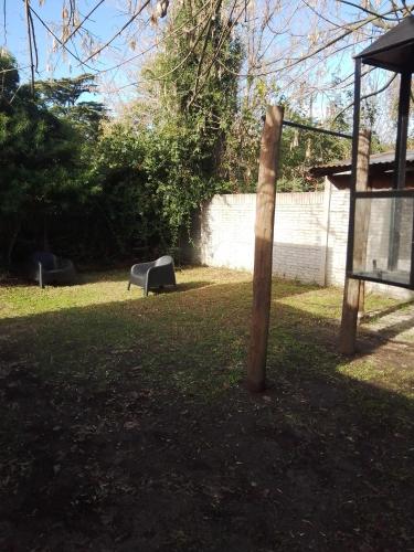 a wooden pole in a yard with two benches at The House II in City Bell