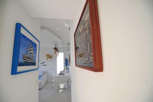 a hallway with two pictures on the wall and a bathroom at Appartamento Rapallo Sky Garden Maria Jose Liguria - Attico vista mare - Terraces - 2 bagni- 2 Camera da Letto - Box, Wi-fi, Idromassaggio Free inteiro Attico per Voi, con Ascensore in Rapallo