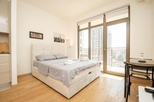 a white bedroom with a bed and a large window at Belgrade Waterfront Nimax in Sajmište