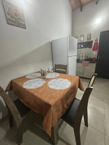 a dining room table with chairs and a refrigerator at Chalet mi República in Zarate Isla