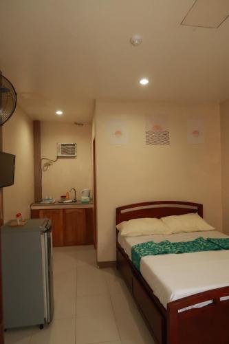 a bedroom with a bed and a sink in it at Jo-Cris Apartelle in Mactan