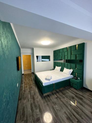 a bedroom with a bed with a green headboard at Regim Relax 2 in Bucharest