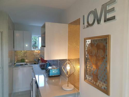 a kitchen with a table with a lamp on it at Book Now Affordable Cute Cozy studio with Carpark 23 in Auckland