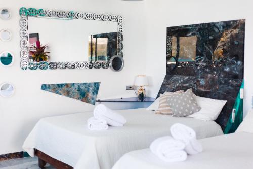 two beds in a room with a mirror and towels at Sunset Samana in Las Galeras