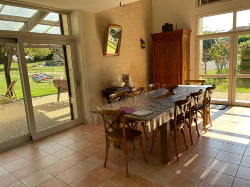 une salle à manger avec une grande table et des chaises dans l'établissement Gîte de charme avec terrasse et activités familiales à Payré, près de Fontenay-le-Comte - FR-1-426-170, à Payré-sur-Vendée