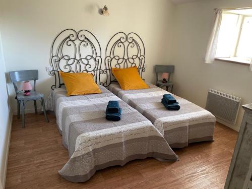 two beds in a room with yellow pillows at Gîte de charme avec terrasse et activités familiales à Payré, près de Fontenay-le-Comte - FR-1-426-170 in Payré-sur-Vendée