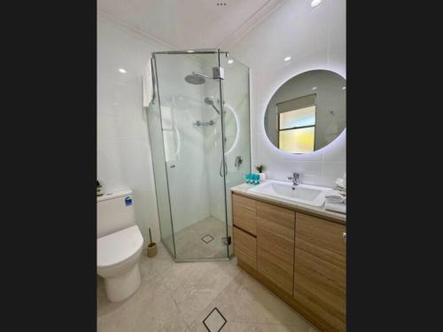 un bagno con doccia, WC e lavandino di Reef Terraces on St Crispins a Port Douglas