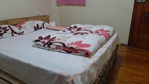 a bed with a white and red blanket on it at Albergue Camry Backpackers佳美背包客旅馆 in Cuenca