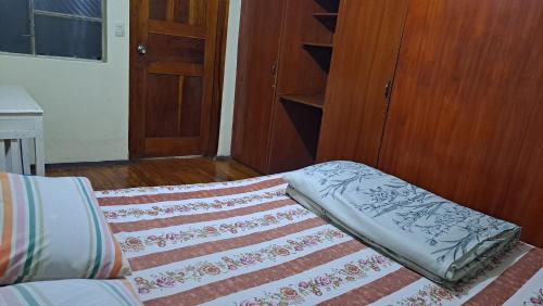 a room with a bed with a rug and a door at Albergue Camry Backpackers佳美背包客旅馆 in Cuenca