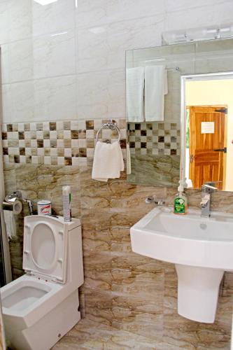 a bathroom with a toilet and a sink at Bluewater Beach Resort in Trincomalee