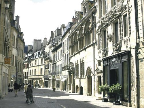 a group of people walking down a street with buildings at L'aparthoteL LhL in Dijon