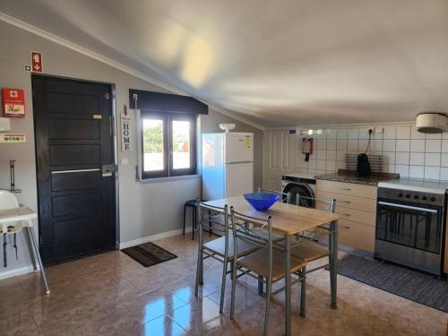 a kitchen with a table and chairs and a kitchen with a refrigerator at Affordable Ocean Views! Zambujeira, Lourinha in Serra do Calvo