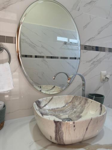 a bathroom with a marble sink and a mirror at Chilamate Room 2 in Tortuguero