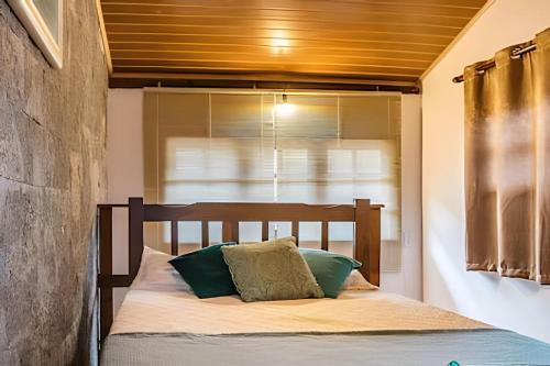 uma cama com cabeceira de madeira em um quarto em Morada dos Pássaros | Pertinho da Praia do Curral em Ilhabela