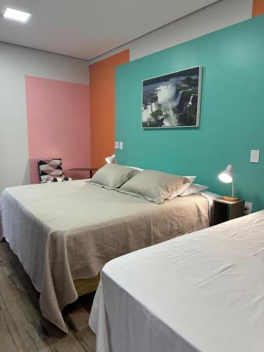 two beds in a room with colorful walls at Pequeno Paraíso in Foz do Iguaçu