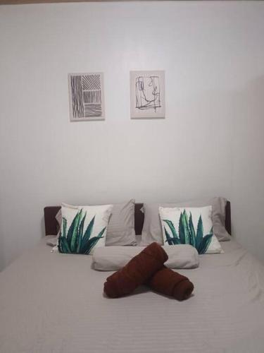 a bed with three pillows and a stuffed animal on it at CM Heights Homey 2 bedrooms in General Santos