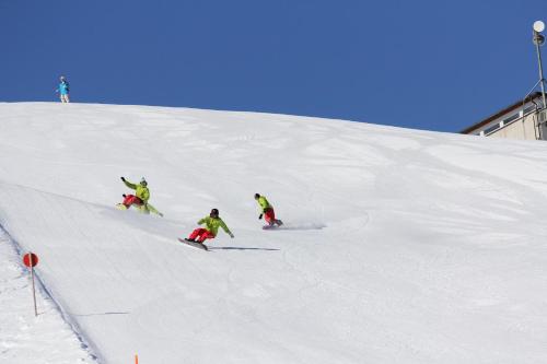 three people are skiing down a snow covered slope at Haus am Rain in Partenen