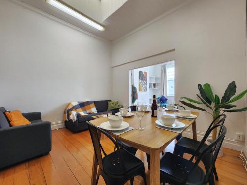 a living room with a wooden table and chairs at U Suites on Cuba in Wellington