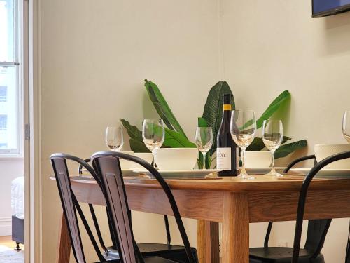 a wooden table with wine glasses and a plant at U Suites on Cuba in Wellington