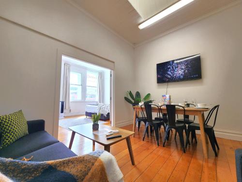 a living room with a table and a dining room at U Suites on Cuba in Wellington