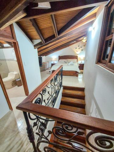 a staircase leading to a bedroom with a bed at Apartahotel saquenzipá in Villa de Leyva
