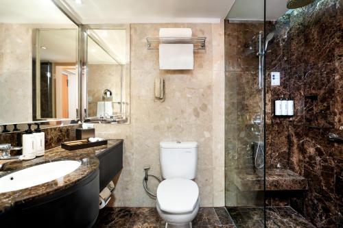 a bathroom with a toilet and a sink and a shower at voco Orchard Singapore by IHG in Singapore