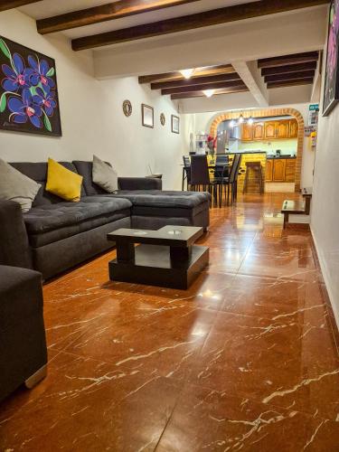 a living room with a couch and a table at Apartahotel saquenzipá in Villa de Leyva