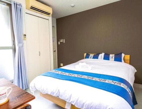 a bedroom with a large bed and a table at F HOUSE Os Residence D3 in Osaka
