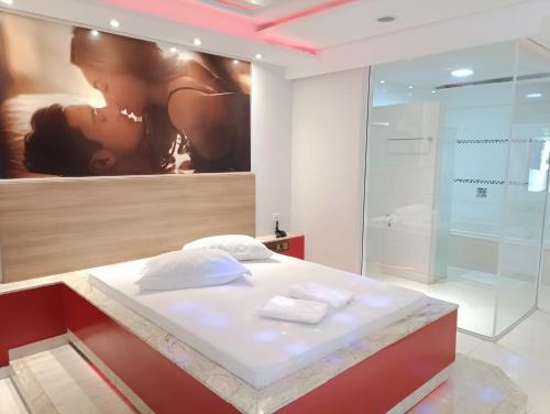 a bathroom with a bed and a shower in a room at motel chanty in Piracicaba