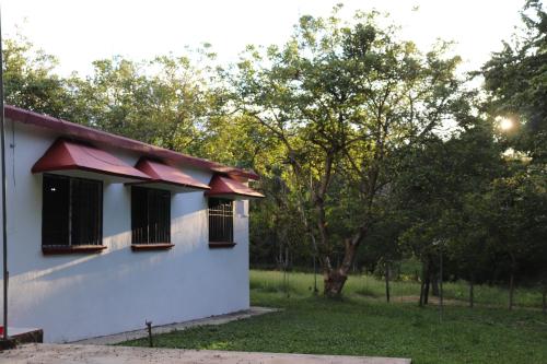 a white house with black windows and a yard at Harmony in Palenque