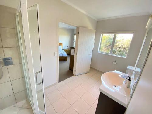 a bathroom with a shower and a sink and a mirror at Russell's Secluded Secret in Russell