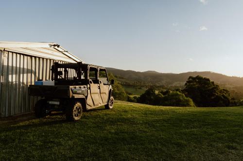 a white truck parked in the grass near a building at Family Fun On The Farm! Close to Kenilworth Stylish Feed Friendly Cows Breathtaking 360 Views in Obi Obi