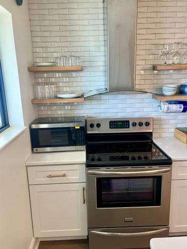 a kitchen with stainless steel appliances and white cabinets at Luxe by the Sea - 5-Star Beachfront Escape in Myrtle Beach