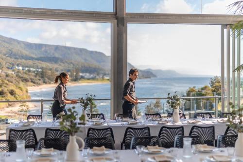 a table set up for a wedding with a view of the ocean at Headlands Austinmer Beach in Austinmer