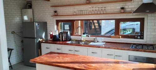 a kitchen with a sink and a refrigerator at Hermosa casa parcela puerto varas in Puerto Varas